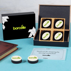 Open box featuring chocolates and butter‑paper message plus edible logo