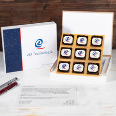 Open wooden box with 9 logo chocolates and personalized butter‑paper message – company anniversary gifts