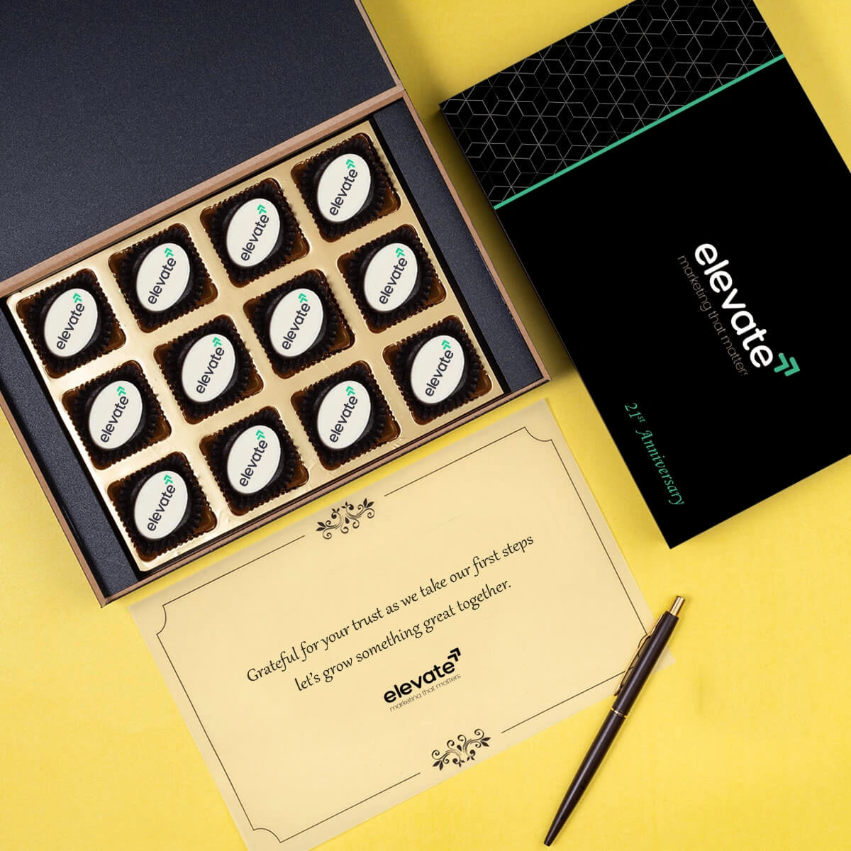 Flatlay of 12 logo-printed chocolates in sleek box