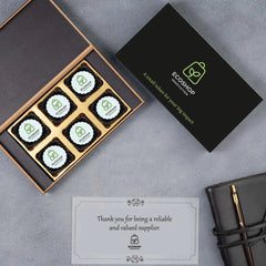 Flat‑lay view: chocolate box, branded chocolates, and corporate stationery layout