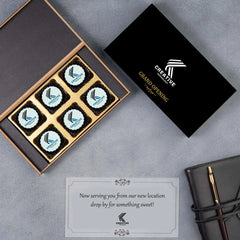 Closed black wooden box with elegant ribbon and logo label.