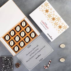 Festive holiday scene: wooden box with logo chocolates surrounded by snowflake decor