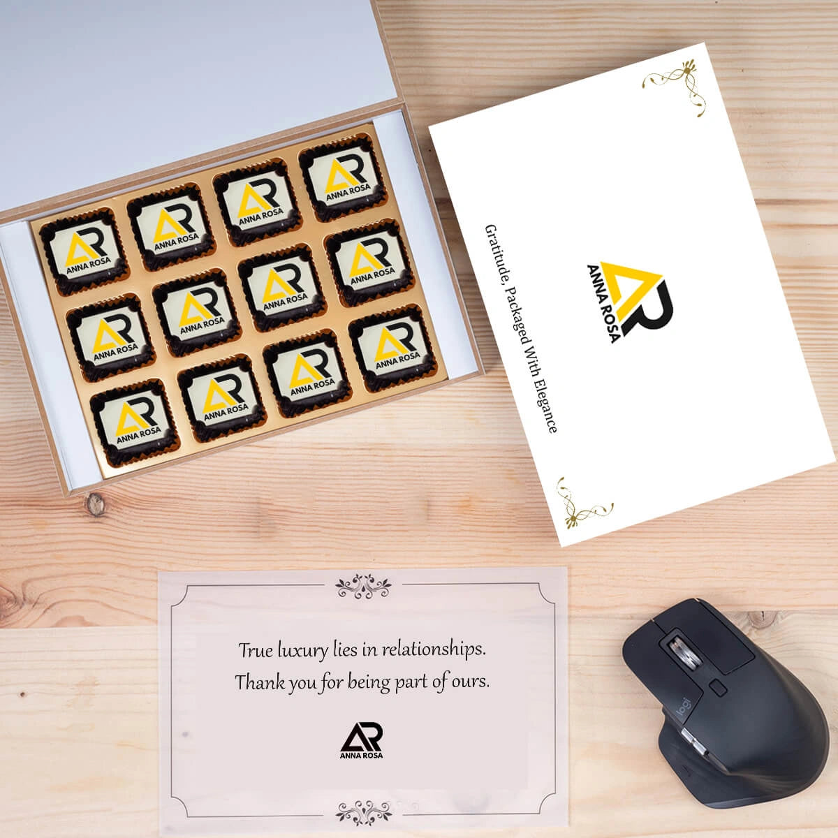 White wooden box open to show logo‑branded chocolates atop personalized message