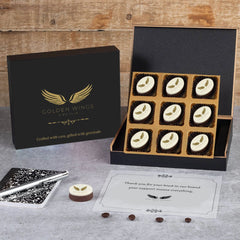 Black wooden gift box open to reveal branded chocolates and elegant packaging