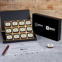 Rebranding gift box open to display mixed pralines printed with new logo and promotional insert